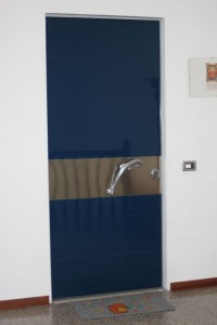 Porta blindata con rivestimento in vetro e fascia in acciaio inox